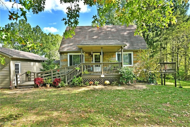 rear view of property with a deck and a lawn