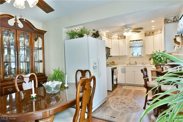 dining area with ceiling fan, sink, and light hardwood / wood-style flooring