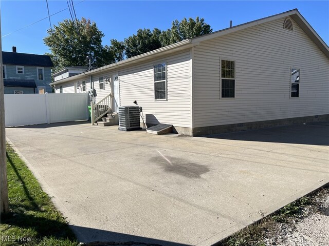 view of side of home with central AC