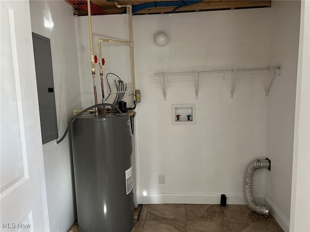 washroom featuring dark tile patterned floors, electric panel, electric water heater, and washer hookup