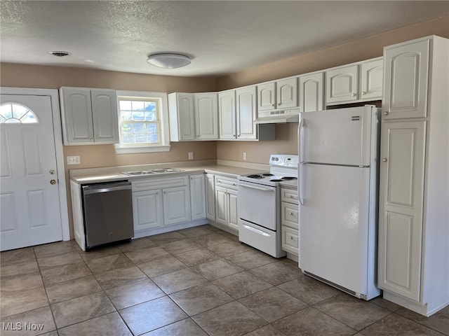 kitchen with white cabinetry, a textured ceiling, light tile patterned floors, and white appliances