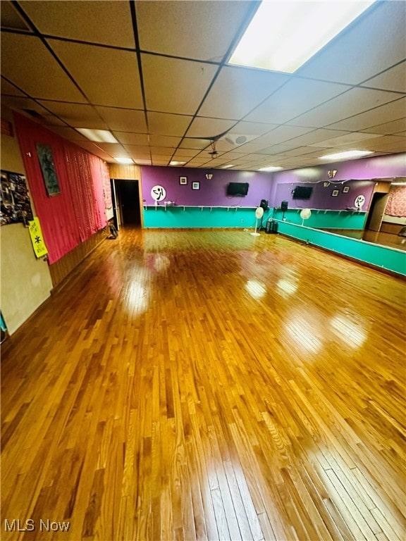 workout room with wood-type flooring and a drop ceiling