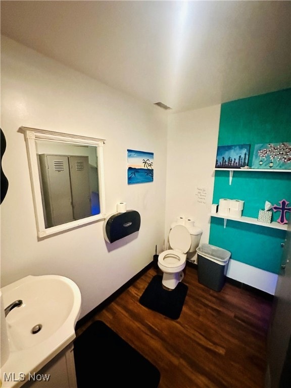 bathroom with hardwood / wood-style floors, vanity, and toilet