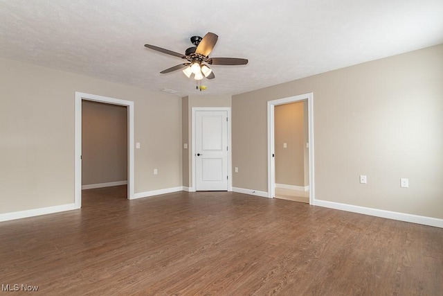 spare room featuring ceiling fan and dark wood-type flooring