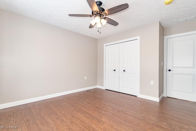 unfurnished bedroom featuring ceiling fan, a closet, and dark hardwood / wood-style flooring