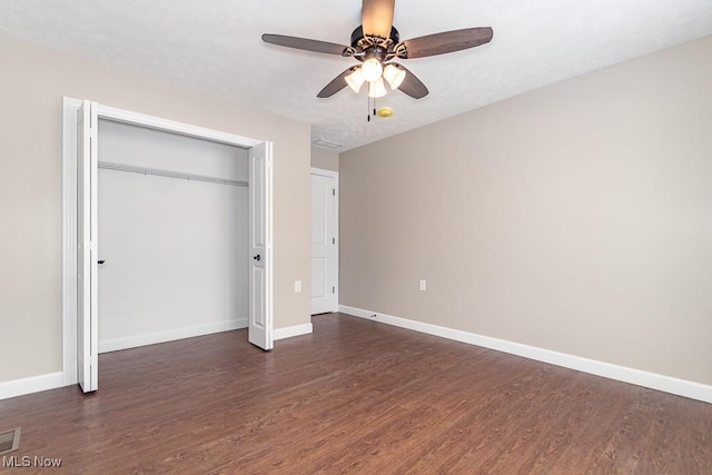 unfurnished bedroom with ceiling fan, a closet, and dark wood-type flooring