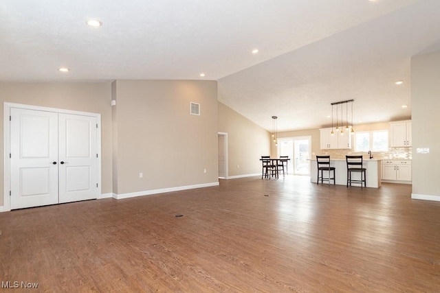 unfurnished living room with high vaulted ceiling and dark hardwood / wood-style flooring