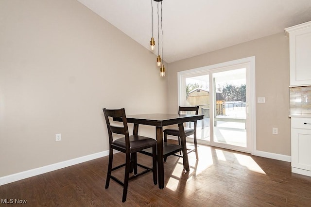 dining area featuring dark hardwood / wood-style floors and lofted ceiling