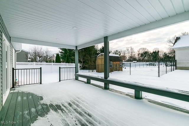 snow covered deck with a shed