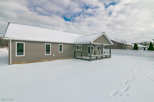 snow covered house featuring a porch