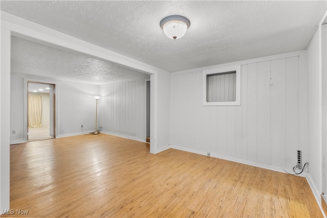 empty room featuring light hardwood / wood-style flooring and a textured ceiling