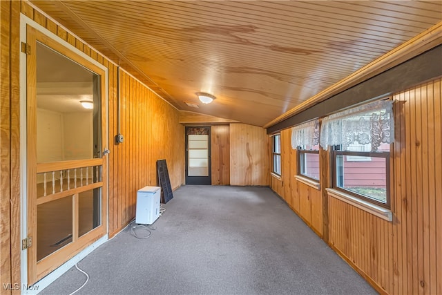 interior space featuring wood walls, carpet flooring, wooden ceiling, and vaulted ceiling