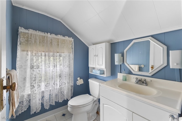 bathroom featuring vaulted ceiling, toilet, ornamental molding, vanity, and tile patterned flooring