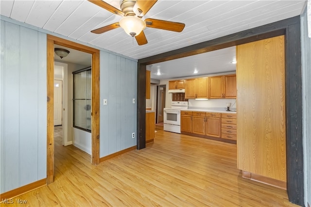 kitchen featuring wood walls, ceiling fan, light wood-type flooring, and white range oven