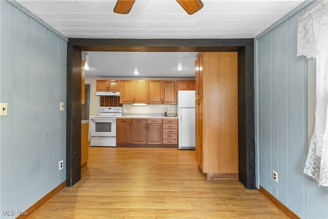 kitchen with white appliances, tasteful backsplash, light hardwood / wood-style floors, ceiling fan, and wooden walls