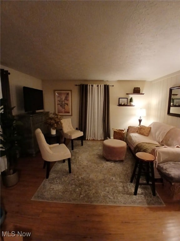 living room with a textured ceiling and hardwood / wood-style floors