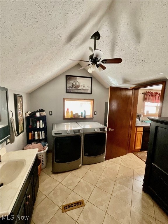 bathroom with lofted ceiling, ceiling fan, independent washer and dryer, and a textured ceiling