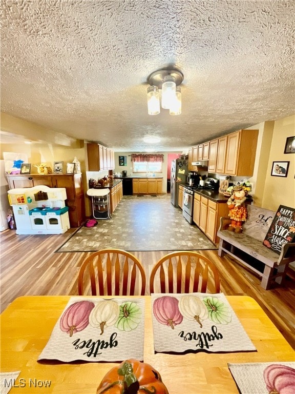 dining space featuring hardwood / wood-style flooring and a textured ceiling