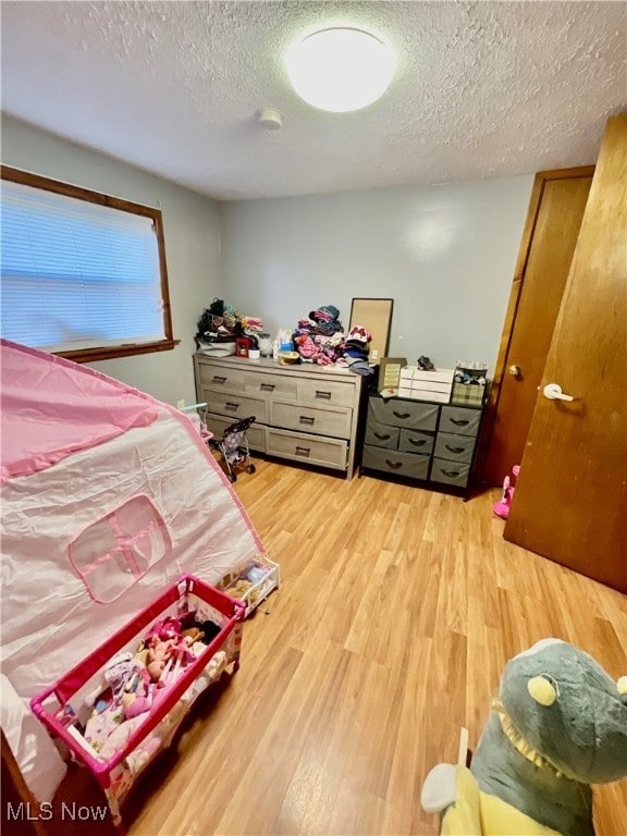 bedroom featuring hardwood / wood-style flooring and a textured ceiling