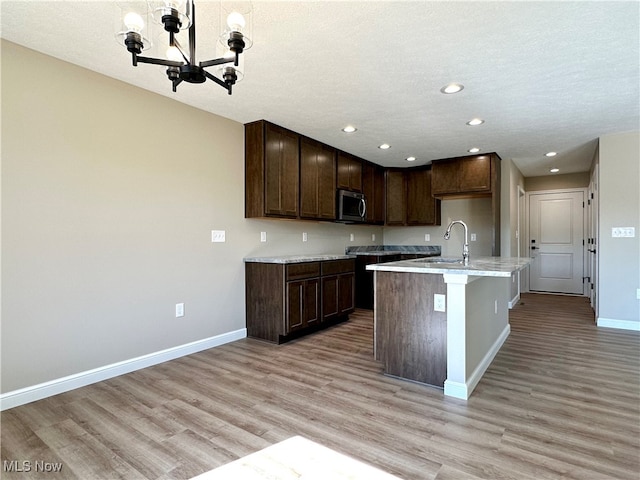 kitchen featuring pendant lighting, light hardwood / wood-style flooring, a textured ceiling, and sink