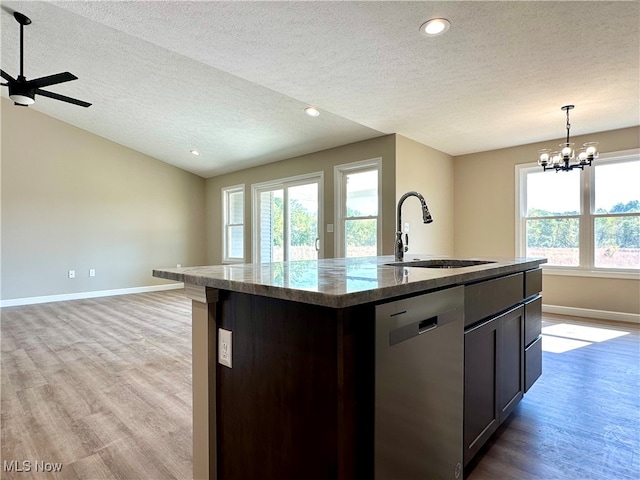 kitchen featuring dishwasher, an island with sink, light hardwood / wood-style floors, and a wealth of natural light