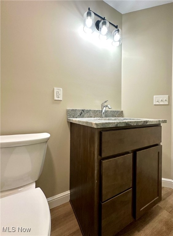 bathroom featuring vanity, toilet, and hardwood / wood-style flooring