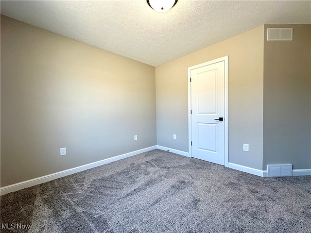 carpeted empty room with a textured ceiling