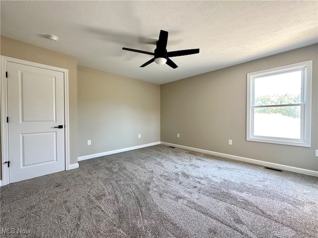 unfurnished room with carpet floors, ceiling fan, and a textured ceiling