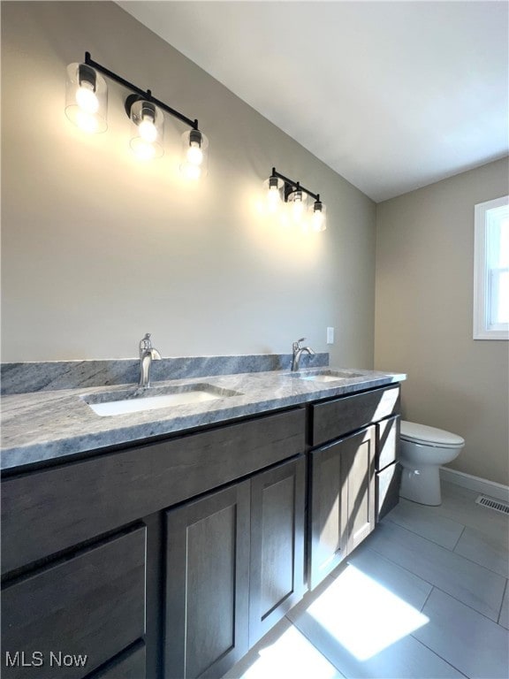 bathroom featuring tile patterned floors, vanity, and toilet