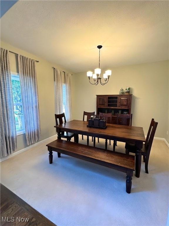 carpeted dining space featuring an inviting chandelier