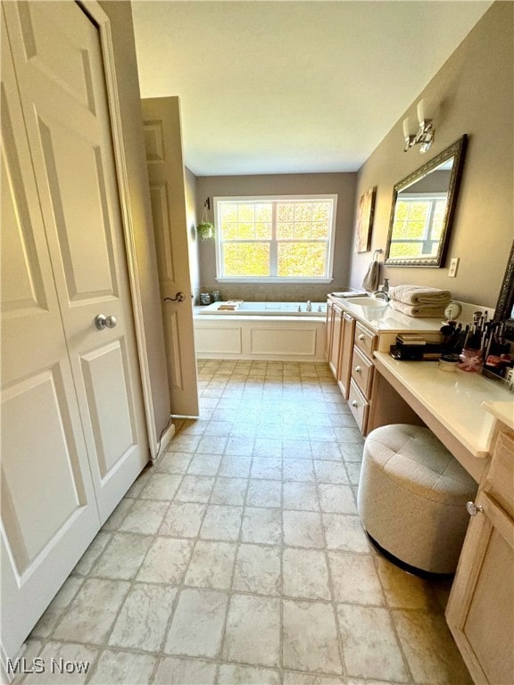 bathroom with vanity and a washtub