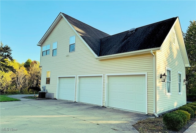 view of property exterior featuring central air condition unit and a garage