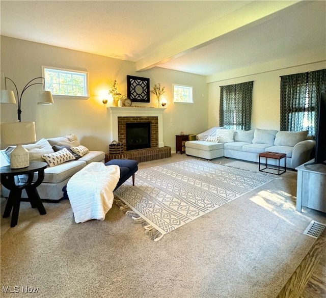 living room with carpet floors, beamed ceiling, and a fireplace