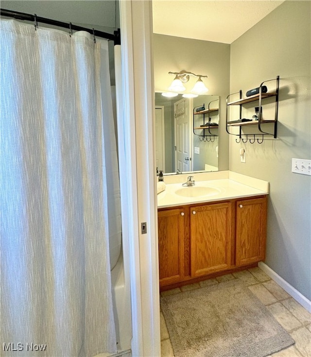 bathroom featuring shower / tub combo with curtain, tile patterned floors, and vanity