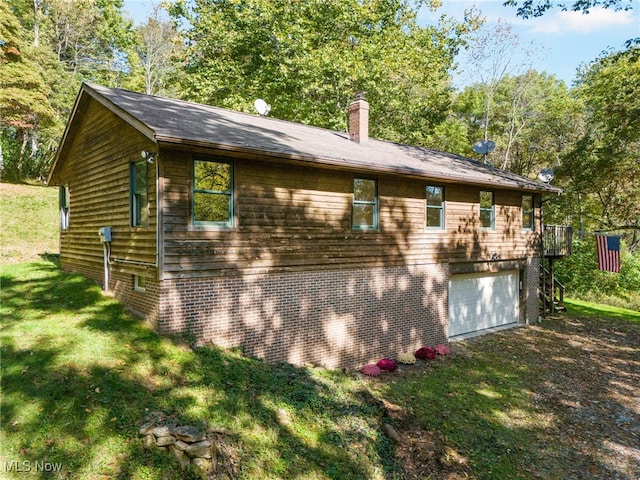 view of side of home featuring a yard and a garage