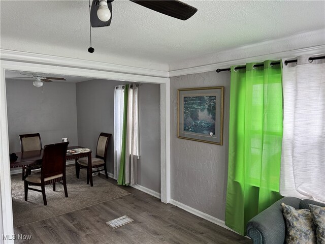 office area with ceiling fan, a textured ceiling, and dark wood-type flooring