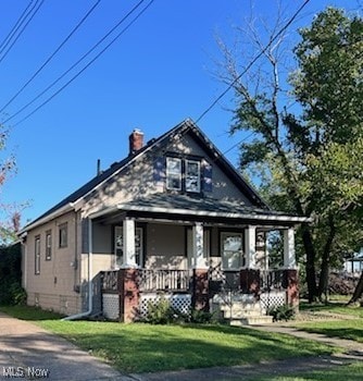 bungalow-style home featuring a porch and a front lawn