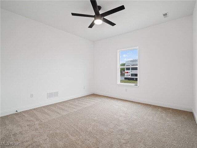 carpeted spare room featuring ceiling fan