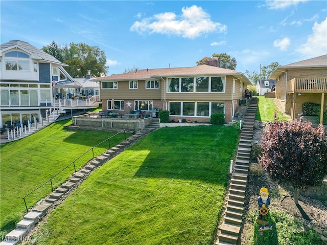 back of property with a deck and a lawn