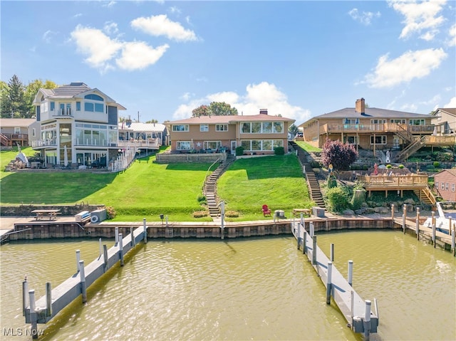 view of dock with a water view and a lawn