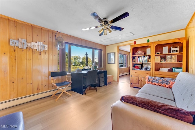 living room with light wood-type flooring, a baseboard heating unit, and a textured ceiling