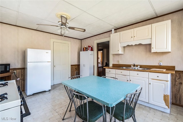 kitchen with white appliances, butcher block counters, and wooden walls