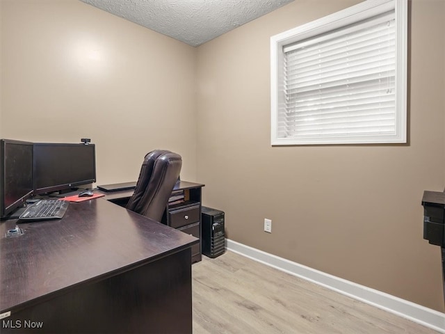 office with light hardwood / wood-style flooring and a textured ceiling