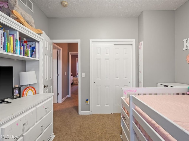 bedroom with light colored carpet, a textured ceiling, and a closet