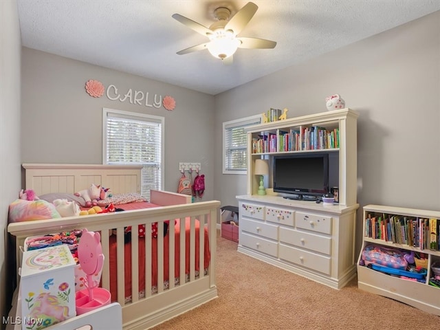 carpeted bedroom featuring a textured ceiling and ceiling fan