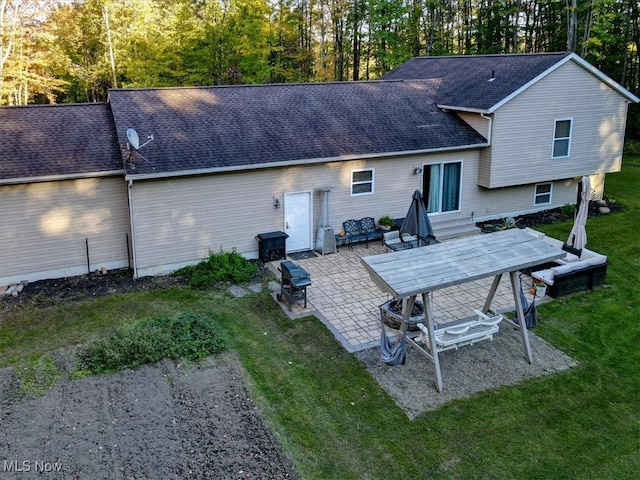 rear view of house with a yard and a patio area