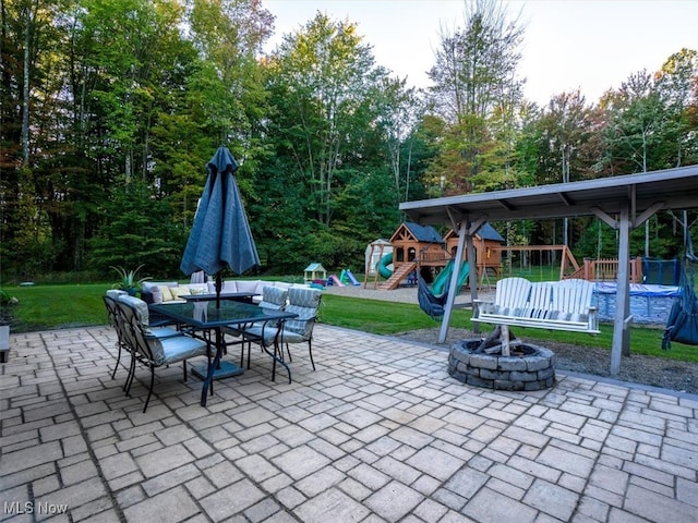 view of patio / terrace with a playground and a fire pit