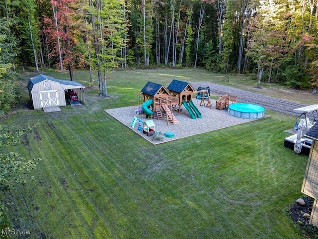 view of jungle gym with a yard and a shed