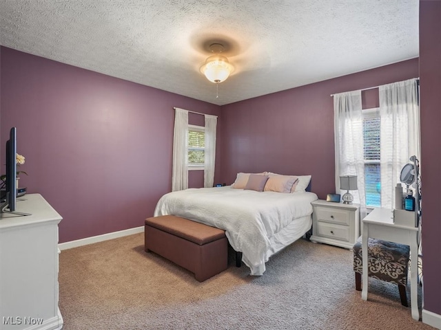 carpeted bedroom featuring a textured ceiling and multiple windows