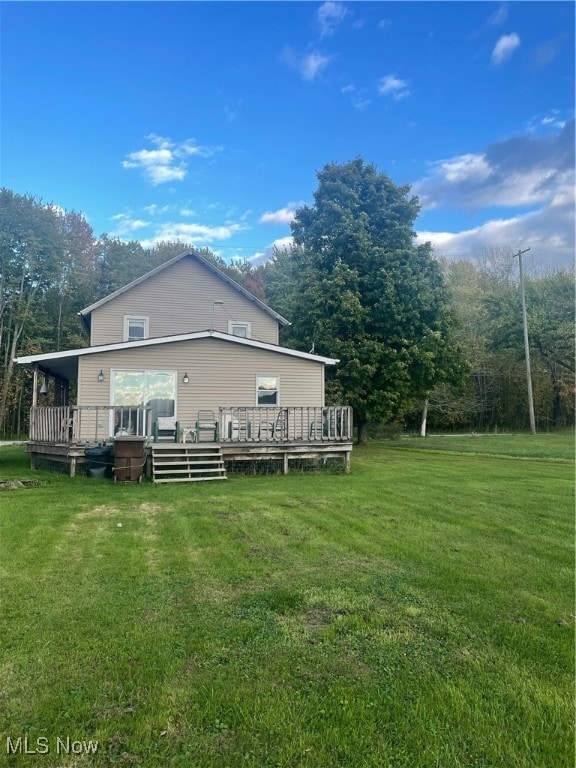 back of property with a yard and a deck